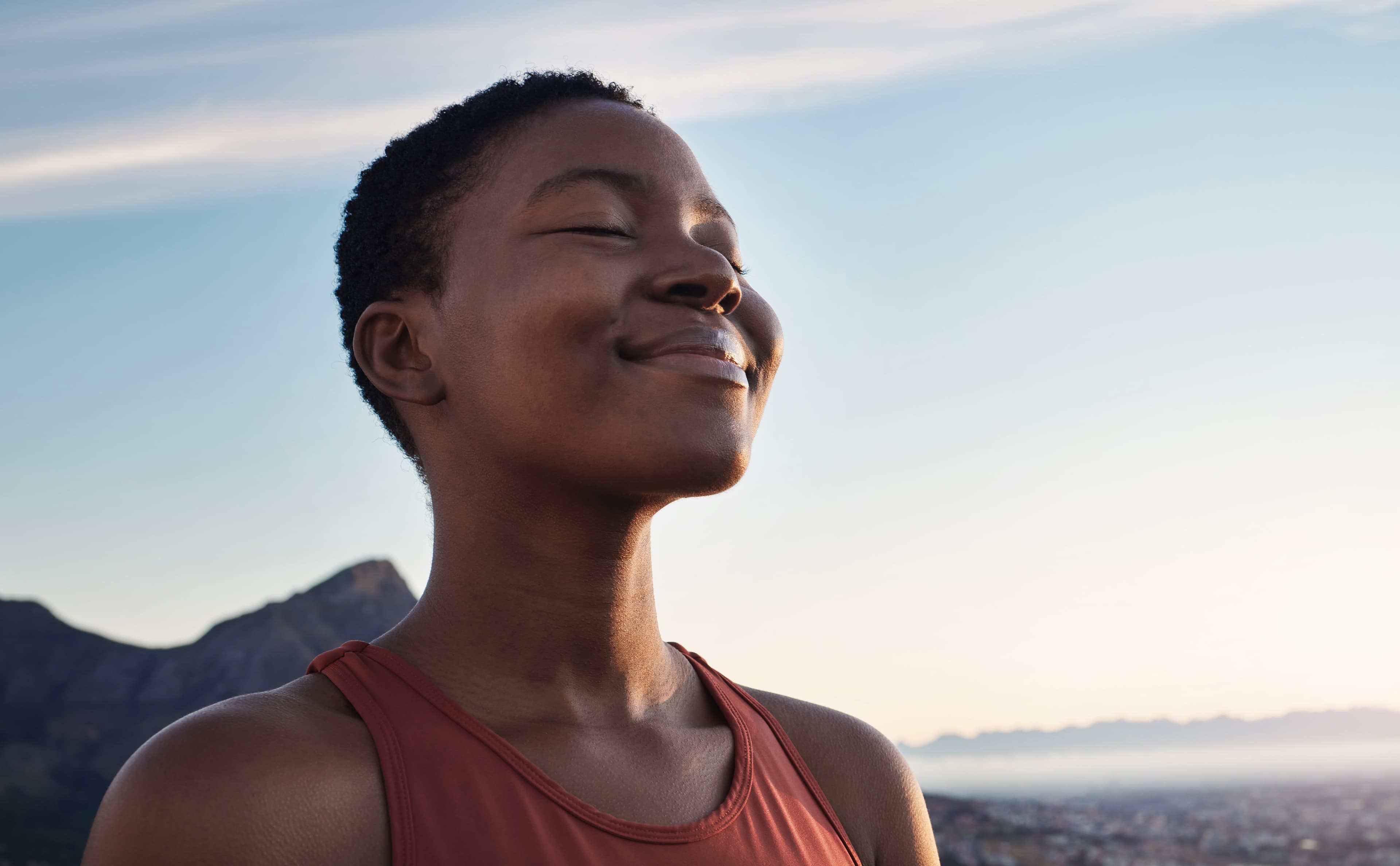 woman feeling the warm sun on her face